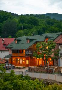 ein großes Haus mit grünem Dach in der Unterkunft Guesthouse Sandra in Kolašin