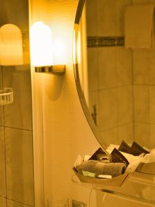 a bathroom with a mirror and a pile of towels at Hotel Massa in Blatten bei Naters