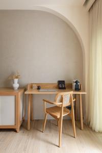 a wooden desk with a chair and a table at Antigoni Seaside Resort in Ormos Panagias