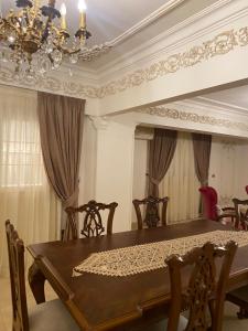 a dining room with a table and a chandelier at Luxurious, fully furnished and well-equipped apartment with modern amenities, stunning views, and convenient location for remote work or studying from home in Cairo