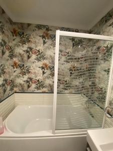 a bath tub in a bathroom with floral wallpaper at Luxurious, fully furnished and well-equipped apartment with modern amenities, stunning views, and convenient location for remote work or studying from home in Cairo