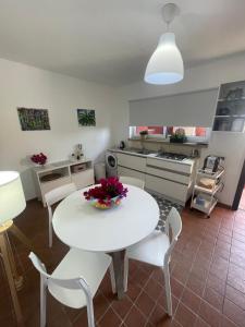 uma cozinha com uma mesa branca e cadeiras brancas em Villa Bella em Augusta