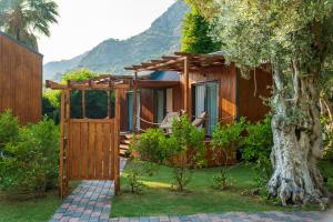 a wooden house with a gate and a tree at Sugar Beach Club in Oludeniz
