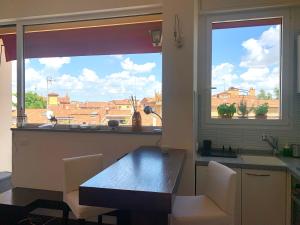 een keuken met een tafel en een groot raam bij Charming Home Towers-Roofs View in Bologna +32 foto's
