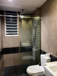 a bathroom with a toilet and a glass shower at Zetapark, The Loft in Kuala Lumpur