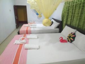 2 łóżka z ręcznikami i kapciami w pokoju w obiekcie Sanjana Home Stay w mieście Habarana
