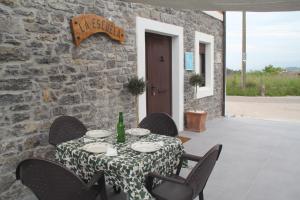 a table and chairs with a table and a stone wall at Casa vacacional Escuela la Llera in Colunga