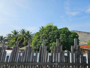 a wooden fence with palm trees in the background at MGS Property in General Santos