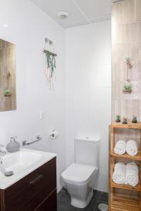 uma casa de banho com um WC branco e um lavatório. em Ibanova Homes Casco Antiguo 2 em Valência