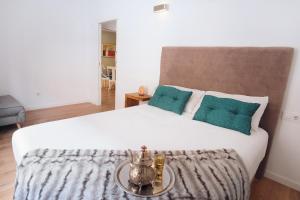 - une chambre avec un grand lit blanc et des oreillers verts dans l'établissement Ibanova Homes Casco Antiguo 2, à Valence