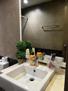 een badkamer met een witte wastafel en een spiegel bij Zetapark, The Loft in Kuala Lumpur