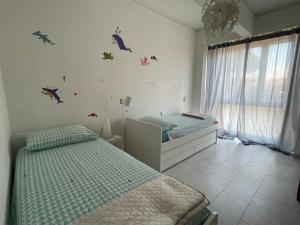 a bedroom with two twin beds and dinosaur decals on the wall at Lara's Apartment in Lido di Camaiore