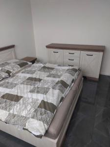 a bedroom with a bed and a wooden dresser at Bezbariérový apartmán Lodenica - v tesnej blízkosti Adelli centra in Piešťany