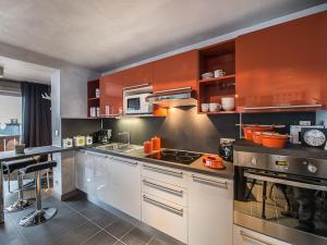 a kitchen with orange cabinets and a stove at Appartement Courchevel 1650, 3 pièces, 6 personnes - FR-1-563-8 in Courchevel