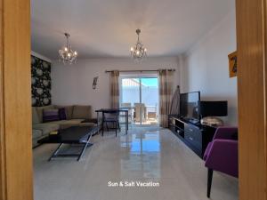 a living room with a couch and a tv and a table at Cabanas de Tavira Smashing 2 bed, 2 bath, Duplex Penthouse in Cabanas de Tavira