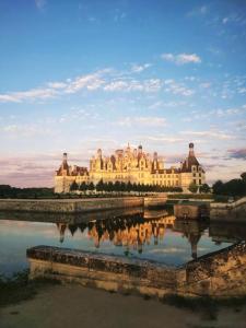 a building with its reflection in a body of water at Détente à Mont-près-Chambord in Mont-près-Chambord