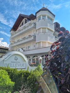 duży biały budynek z znakiem przed nim w obiekcie Park Hotel Bellevue w mieście Dobbiaco