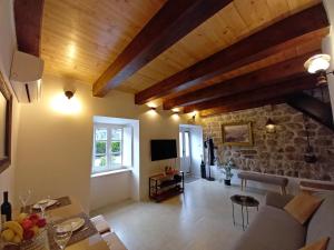 a living room with wooden ceilings and a stone wall at Romantic stone house by the sea **** in Kotor