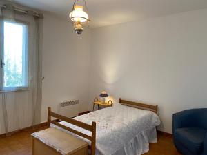 ein Schlafzimmer mit einem Bett, einem Stuhl und einem Fenster in der Unterkunft Casa Minnana in Figari