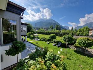 Blick auf einen Garten mit einem Berg im Hintergrund in der Unterkunft Park Hotel Bellevue in Toblach