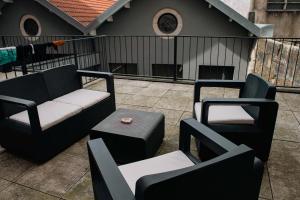 un patio con 2 sillas, un sofá y una mesa en Formosa Patio with Free Parking, en Oporto
