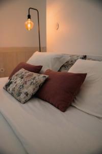 Una cama con sábanas blancas y almohadas. en Formosa Patio with Free Parking, en Oporto