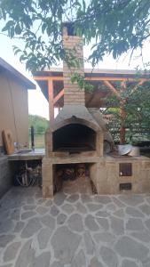 a stone outdoor oven with a roof on a patio at Casa Moața La Vama Veche in Vama Veche +30 photos