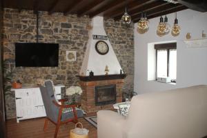 uma sala de estar com lareira e televisão em Casa vacacional Escuela la Llera em Colunga