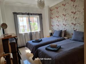 a bedroom with two beds and a window at Cabanas de Tavira Smashing 2 bed, 2 bath, Duplex Penthouse in Cabanas de Tavira +30 photos