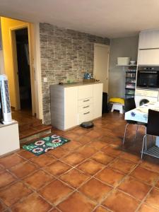 a kitchen with a tiled floor with a table and a counter at La Cabaña del tío Tom in Veigue