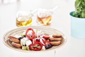 a plate of food with a salad on a table at Antigoni Seaside Resort in Ormos Panagias