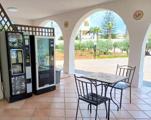 una mesa y sillas junto a una máquina expendedora en Oasi del Borgo, en Borgo Bonsignore