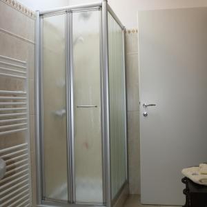 um chuveiro com uma porta de vidro na casa de banho em La Bici Bianca em Imperia