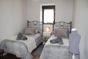 um quarto com 2 camas e uma janela em Casa vacacional Escuela la Llera em Colunga