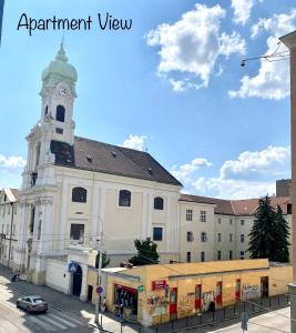 um grande edifício branco com uma torre de relógio numa rua em BRAND NEW Design studio Emerald - old town A/C em Bratislava