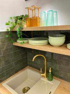 a kitchen sink with plates and bowls on a shelf at BRAND NEW Design studio Emerald - old town A/C in Bratislava