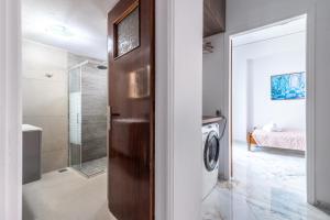 a bathroom with a shower and a washing machine at Cretan Village Renovated House in Heraklio Town