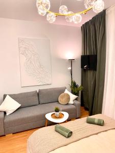 uma sala de estar com um sofá e uma mesa em BRAND NEW Design studio Emerald - old town A/C em Bratislava