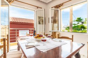 una sala da pranzo con tavolo e 2 finestre di Cretan Village Renovated House a Heraklion