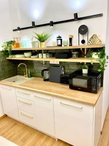 a kitchen with white cabinets and a microwave at BRAND NEW Design studio Emerald - old town A/C in Bratislava