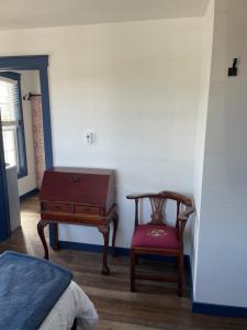 ein Schlafzimmer mit einem Tisch, einem Stuhl und einem Stuhl in der Unterkunft Duncklee Room 202, Hyland Hotel in Palmer