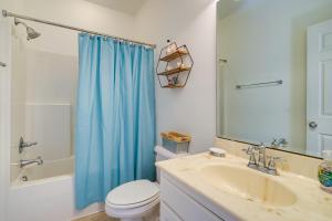 y baño con lavamanos y cortina de ducha azul. en Carolina Beach Lakefront House Walk to Beach!, en Carolina Beach 24 fotos más