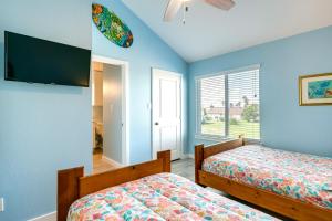 two beds in a bedroom with blue walls at Bright Key Allegro Condo with Community Outdoor Pool in Rockport