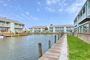 a dock in front of a row of apartment buildings at Bright Key Allegro Condo with Community Outdoor Pool in Rockport