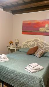 Un dormitorio con una cama verde con una pintura en la pared en Le dimore di Gió, en Trapani
