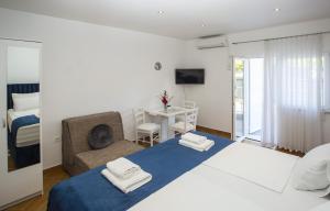 a bedroom with a bed and a chair and a desk at Guest House Kušeta in Split