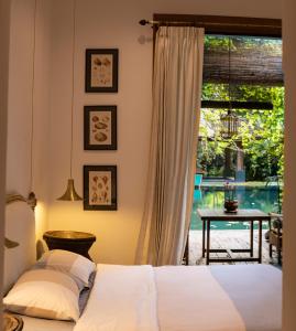 a bedroom with a bed and a view of a pool at Chandra Residence in Chiang Mai