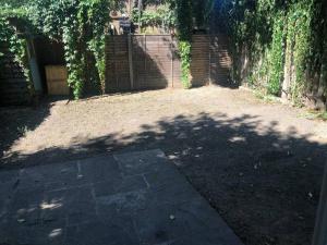 un patio sombrío con una gran sombra de árbol en Entire Private House in the Heart of London en Londres