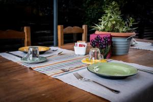 a wooden table with plates and utensils on top at LaZita B&B in Montecastrilli