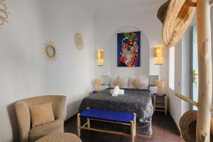 um quarto com uma cama e uma cadeira num quarto em Riad Pierres et Saveurs Soleil em Marrakech
